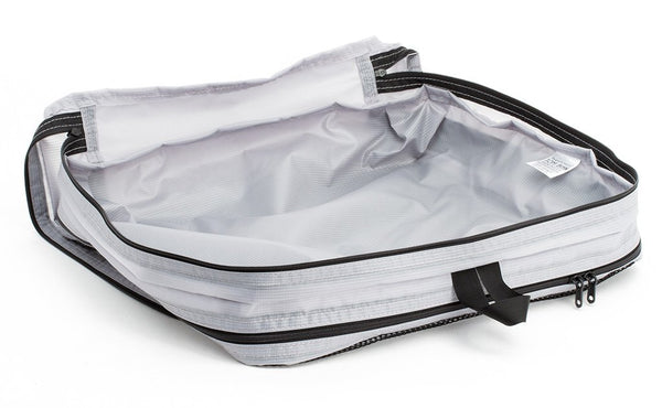 An empty and open Northwest Sky (light grey) Aether Large Aeronaut 45 Packing Cube open all-fabric side up.